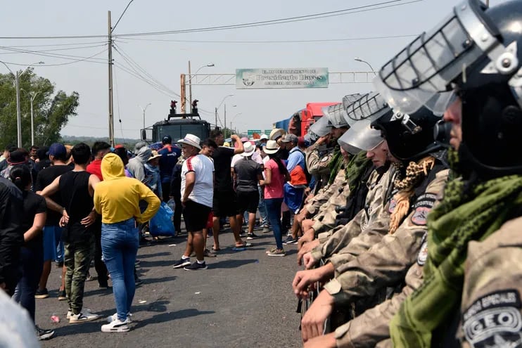 Policías antimotines observan a comerciantes de fronteras que se oponen a los controles en la frontera con Nanawa.