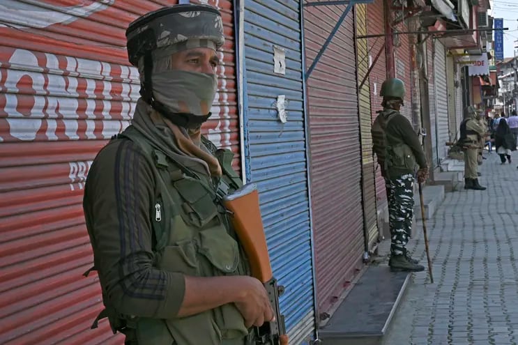 Soldados paramilitares indios montan guardia frente a comercios cerrados en la ciudad de Srinagar.