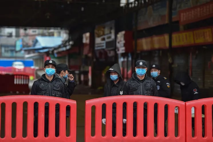 Policías fuera del mercado de mariscos Huanan de Wuhan, China, en enero de 2020.
