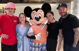 David y Victoria Beckham con sus hijos menores Cruz y Harper posando con Mickey.