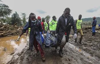 Rescatistas transportan un cuerpo recuperado en una zona inundada en la localidad de Kamuchira, Kenia, el pasado martes.
