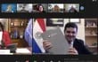 El presidente del Senacsa, Dr. José Carlos Martin, por Paraguay y la directora de la OPS, Dra. Carissa F. Etienne,  en una reunión virtual,  muestran las copias del documento rubricado en forma digital.