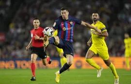 El delantero del FC Barcelona Robert Lewandowski (c) controla un balón ante Raúl Albiol (d), del Villarreal, durante el partido de la décima jornada de Liga en Primera División que disputaron ayer en el Camp Nou, en Barcelona. EFE/Alejandro García