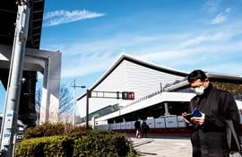 Un ciudadano de Tokio usa un tapaboca, en las inmediaciones del Ariake Arena (fondo), sede de los Juegos.