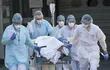 Miembros del cuerpo médico del hospital  Emile Muller, de Mulhouse, Francia, evacuan a un paciente con coronavirus que debe ser trasladado a otro hospital.