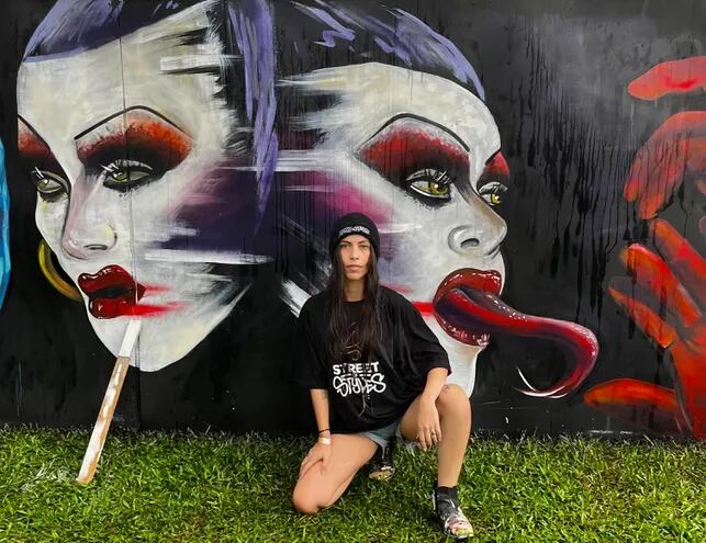 Maccarena Marc posando frente a la obra que presentó en el Festival Internacional de Muralismo Street of Styles, en Curitiba.