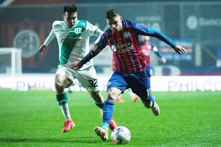 Ángel Romero (d) disputa el balón con Emanuel Coronel durante el partido que San Lorenzo y Banfield empataron anoche 1-1.