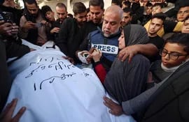 Al Jazeera's bureau chief in Gaza, Wael Al-Dahdouh (C) hugs his daughter as he mourns over the body of his son Hamza Wael Dahdouh, a journalist with the Al Jazeera television network, during his funeral, after he was killed in a reported Israeli air strike in Rafah in the Gaza Strip on January 7, 2024. Dahdouh, who was himself wounded in the arm, lost his wife and two other children in Israeli bombardment in the initial weeks of the war. (Photo by AFP)