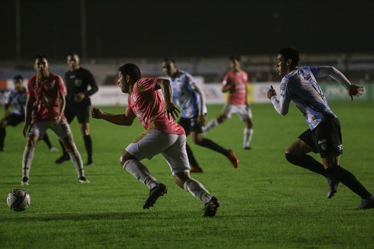 Luis Cabral se lleva el balón y es perseguido por Joel Jiménez en el partido que se disputa en el Parque del Guairá
