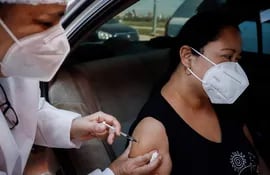 Una mujer recibe una dosis de la vacuna contra la COVID-19, hoy en la Costanera de Asunción.
