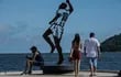 Se ve a personas junto a una estatua que representa a la leyenda del fútbol brasileño Pelé, diseñada por el artista brasileño Luis Costa, en el muelle Rei Pele, en Sao Vicente, costa del estado de Sao Paulo, Brasil.