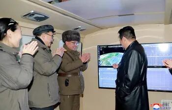 Esta fotografía tomada el 11 de enero de 2022 y publicada por la Agencia Central de Noticias de Corea (KCNA) oficial de Corea del Norte el 12 de enero de 2022 muestra al líder norcoreano Kim Jong Un (derecha) hablando con oficiales militares.