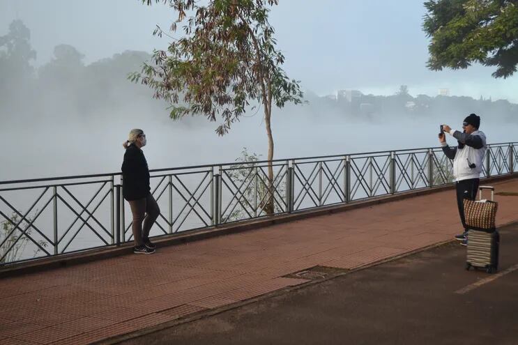 Dos estudiantes brasileños inmortalizan en fotografías su paseo en un ambiente frío, por el lago de la República de Ciudad del Este.
