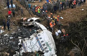 Rescatistas retiran el cuerpo de un víctima del accidente aéreo de Yeti Airlines en Pokhara.