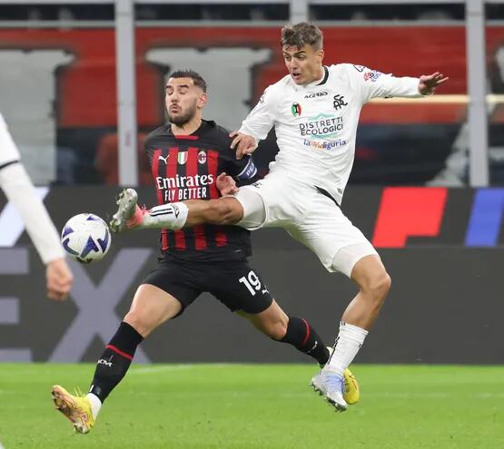 Daniel Maldini (d), delantero de Spezia, disputa el balón con Theo Hernández, capitán del AC Milan, durante el partido de ayer en San Siro.