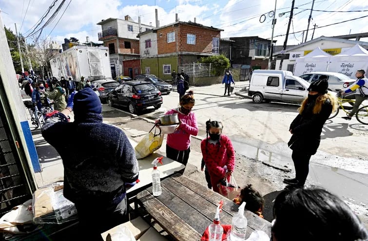 Gente recibiendo alimentos en la Parroquia Virgen de Caacupé, de la Villa 31, en Buenos Aires. La pobreza ha aumentado en una Argentina con una economía duramente golpeada.