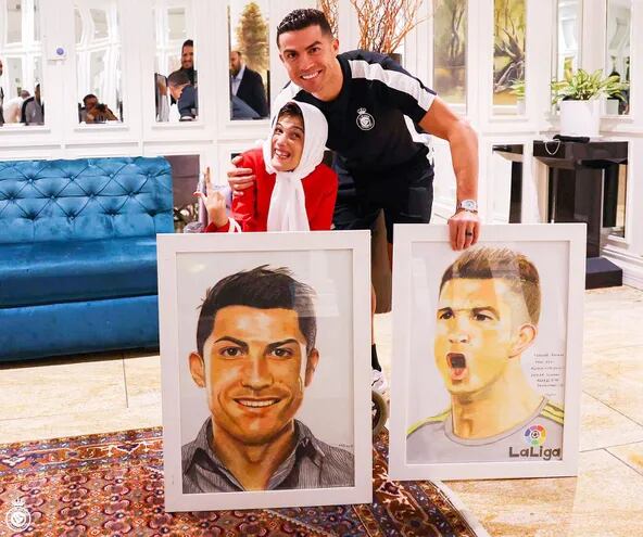 Cristiano Ronaldo abrazando a la artista iraní Fátima Hamami tras recibir los cuadros que le obsequió.