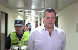Esposado, el exbanquero uruguayo José Peirano Basso es conducido al juzgado penal de garantías N° 1, a cargo de Clara Ruiz Díaz. Fue el jueves pasado.