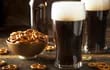 Dos pintas de cerveza negra con pretzels, en la barra de un pub irlandés.