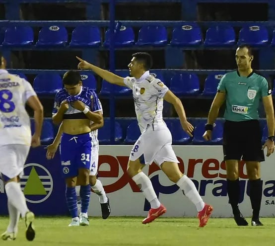 Festejo del volante  auriazul Juan Rodrigo Rojas (36 años) luego de anotar el tanto de apertura en el marcador, en medio de la desazón del solense Marcelo Acosta (23).