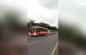 Fila de buses presuntamente listos para las elecciones, mientras pasajeros denuncian quedar varados en la calle.