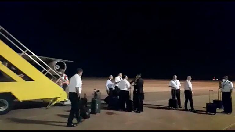 Miembros de la tripulación del avión iraní conversan sobre la pista del Aeropuerto Guaraní.