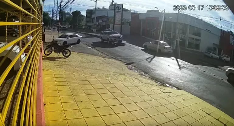 Momento en que una camioneta pasa sobre una moto cuyo conductor intentó adelantarse. La joven víctima salió ilesa.