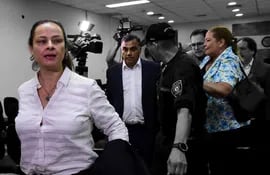 María Selva Morínigo y su esposo Javier Díaz Verón se retiran de la sala de juicios tras ser "blanqueados", escrachados por la activista María Esther Roa.