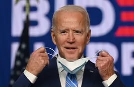 El candidato demócrata a la presidencia de Estados Unidos, Joe Biden, se saca la mascarilla antes de un discurso en el centro Chase en Wilmington, Delaware.