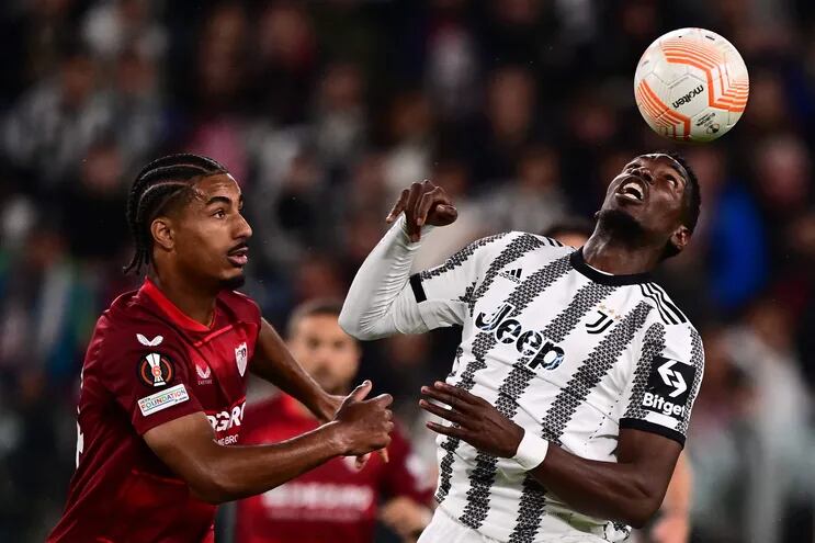 Paul Pogba, de Juventus, intenta controlar el balón ante el acoso de Loic Bade, jugador del Sevilla, durante el partido de ayer.