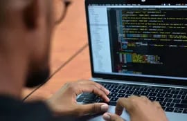 José Pino, hacker colombiano experto en ciberseguridad, revisa algunos códigos en su computador portátil durante una entrevista con Efe.