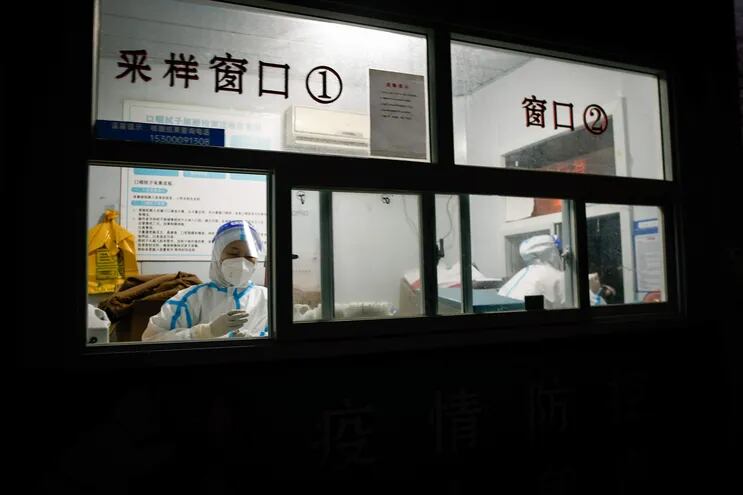 Trabajadores sanitarios trabajan en un centro de toma de muestras de covid-19, en Beijing, China. (EFE/EPA)