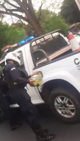 Un agente de policía carga combustible  a la patrullera en plena ruta PY02