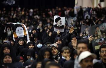 Los iraníes sostienen carteles del difunto presidente Ebrahim Raisi mientras lloran durante la ceremonia de procesiones fúnebres en la mezquita Mossallah en Teherán, Irán.
