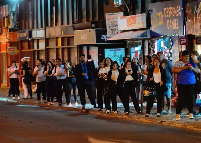 Pasajeros esperando colectivos en horas de la noche en el microcentro de Asunción.