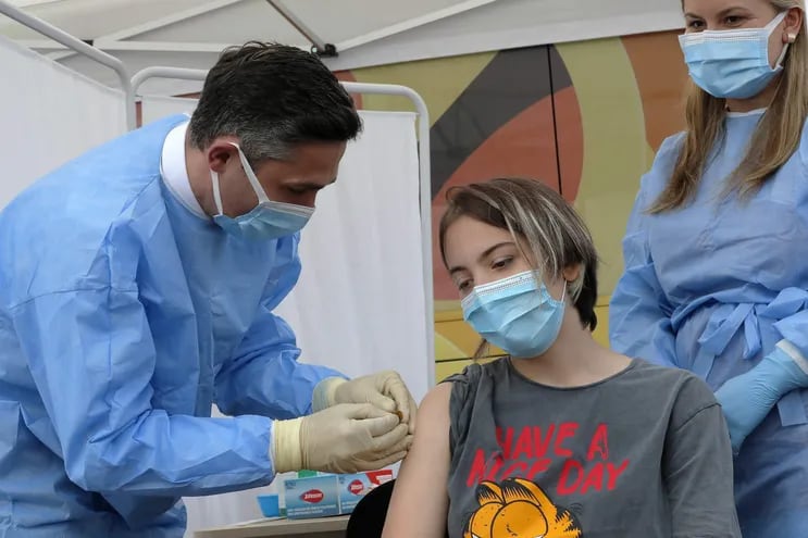 En Rumania, una adolescente recibe una dosis de vacuna anticovid. En Paraguay, se abrirá el registro para personas desde 18 años de edad hasta los 59 con patologías de base.