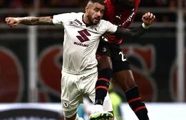 Antonio Sanabria, delantero del Torino, salta en procura del balón contra Fikayo Tomori, zaguero inglés del AC Milan.