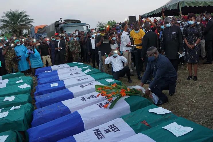 Julius Maada Bio, presidente de Sierra Leona, deja flores sobre los ataúdes de algunas de las víctimas de la explosón en Freetown.