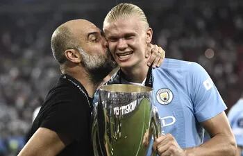 Pep Guardiola le da un beso a Erling Haaland, que sostiene la Supercopa de Europa, conquistada ayer por el Manchester City.