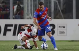 Mario Sandoval (i), futbolista de Curicó Unido, disputa el balón con Diego Churín, jugador de Cerro Porteño, durante la ida de la Fase 2 de la Copa Libertadores 2023, en el estadio Monumental en Santiago de Chile.