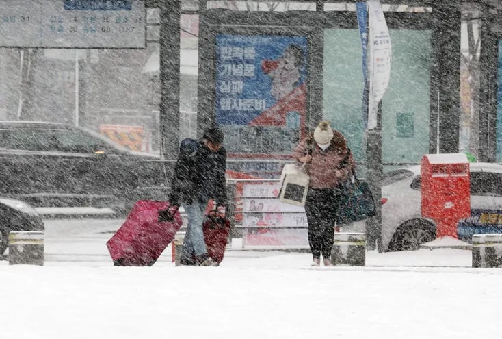 Viajeros atraviesan una nevada en Gwangju, Corea del Sur, el martes.