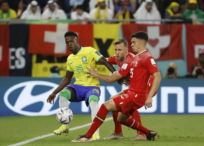 Vinícius Junior (i) de Brasil disputa un balón con Fabian Rieder (d) de Suiza hoy, en un partido de la fase de grupos del Mundial de Fútbol Qatar 2022 entre Brasil y Suiza en el estadio 974 en Doha.
