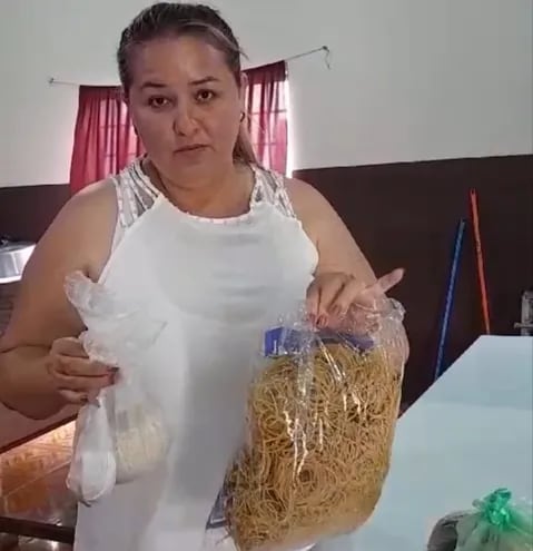 La concejal Elva Villalba muestra algunos de los ingredientes que llegaron para la elaboración del almuerzo de una semana en la escuela básica Nº 5.508 Ñemity del distrito de Naranjal.