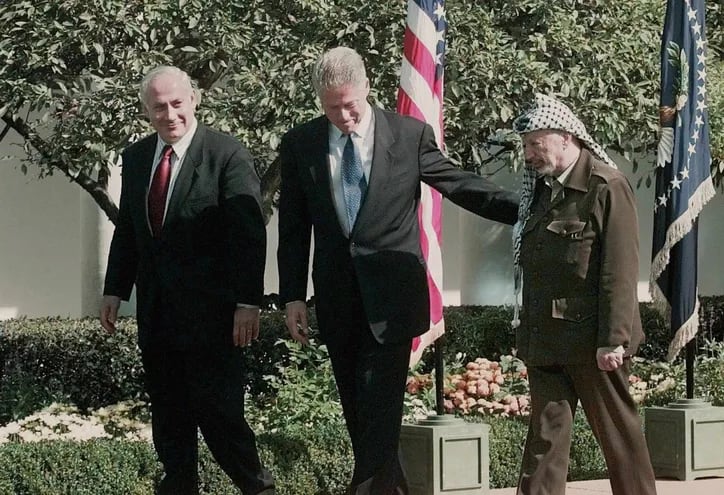 Año 1998. El primer ministro Benjamin Netanyahu (i), junto al entonces presidente de EE.UU., Bill Clinton (C) y líder palestino, Yasser Arafat (d) en el jardín de las rosas de la Casa Blanca.  (AFP, archivo)