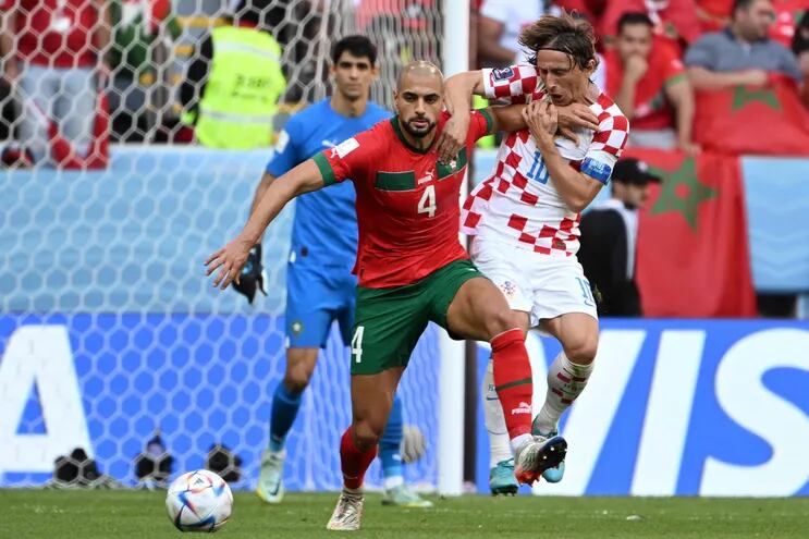 Luka Modric (d), capitán de Croacia, es frenado por el mediocampista marroquí Sofyan Amraba.