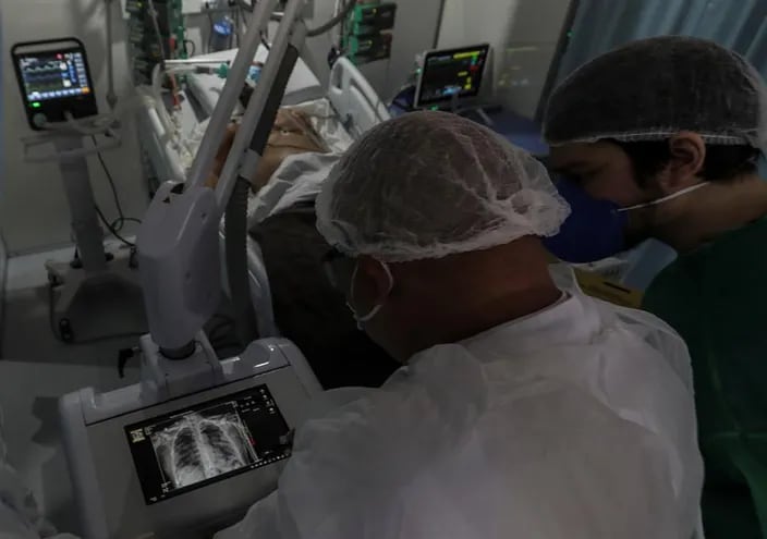 Médicos observan una imagen de rayos x de un paciente con coronavirus en la UTI del hospital de Campaña de Riocentro, en la zona oeste de Río de Janeiro (Brasil).