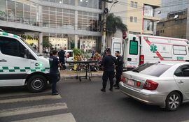 Bomberos asisten al oficial Santiago Figueredo, quien falleció hoy durante un asalto a balazos en la avenida San Martín