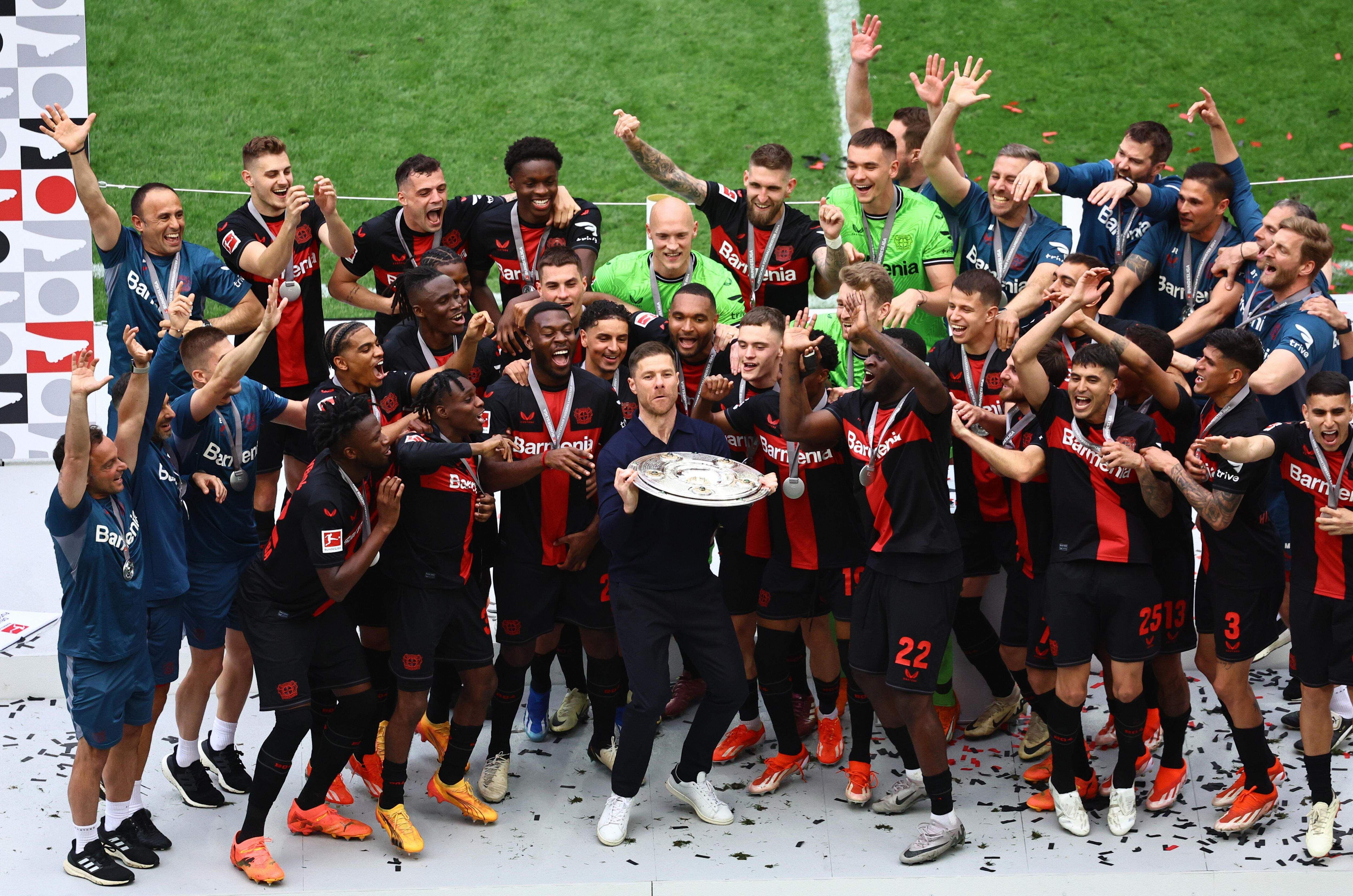 Xavi Alonso (c) y los jugadores del Bayer Leverkusen celebran con el trofeo de la Bundesliga en el Bay Arena, en Leverkusen. 