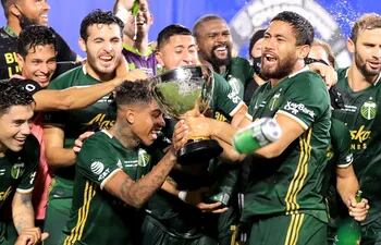 REUNION, FLORIDA - AUGUST 11: Andy Polo #7 (L) and Bill Tuiloma #25 of Portland Timbers celebrate with the MLS Is Back champions trophy after the final match of MLS Is Back Tournament between Portland Timbers and Orlando City at ESPN Wide World of Sports Complex on August 11, 2020 in Reunion, Florida.   Sam Greenwood/Getty Images/AFP
== FOR NEWSPAPERS, INTERNET, TELCOS & TELEVISION USE ONLY ==
