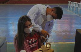 Una joven al momento de recibir su refuerzo contra el COVID-19 en un vacunatorio de Villarrica.